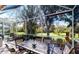 Enjoyable screened porch with table and chairs, overlooking tranquil scenery at 5291 Laurel Oak Ct, North Port, FL 34287
