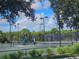 Tennis court with seating area and surrounding landscaping at 5291 Laurel Oak Ct, North Port, FL 34287