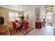 Formal dining room with glass table, red chairs, and decorative chandelier at 5291 Laurel Oak Ct, North Port, FL 34287
