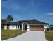Newly built home with a brown garage door and landscaped lawn at 509 Clearview Dr, Port Charlotte, FL 33953
