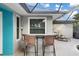 Covered outdoor bar with two wicker barstools at 91 Mark Twain Ln, Rotonda West, FL 33947