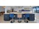 Kitchen island with blue cabinets, white countertop and three barstools at 25188 Marion Ave # E301, Punta Gorda, FL 33950