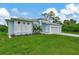 Front view of a charming light blue house with lush landscaping at 1411 Liggett Cir, Port Charlotte, FL 33953