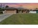 One-story house with a large front yard, showcasing the home's exterior and landscaping at 1858 Norvell Ave, North Port, FL 34286
