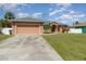 Single story house with a two car garage and well maintained lawn at 1858 Norvell Ave, North Port, FL 34286