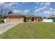 Single-story home with attached garage, driveway, and neat lawn at 1858 Norvell Ave, North Port, FL 34286