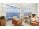 Bright sunroom has beautiful water views, comfortable seating, and wicker furniture at 1 Colony Point Dr # 16B, Punta Gorda, FL 33950