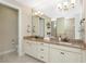 Elegant double vanity bathroom with granite countertops and large mirror at 24211 Savory Ln, Punta Gorda, FL 33955