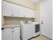 Laundry room with white cabinets, washer, and dryer at 24211 Savory Ln, Punta Gorda, FL 33955