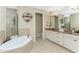 Double vanity bathroom with granite counters and large soaking tub at 24211 Savory Ln, Punta Gorda, FL 33955
