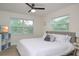 Comfortable bedroom featuring a large bed, ceiling fan, and windows providing natural light and pleasant views at 25 Caddy Rd, Rotonda West, FL 33947