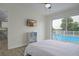 Bright bedroom with a sliding glass door overlooking the pool and a mounted TV for relaxing evenings at 25 Caddy Rd, Rotonda West, FL 33947