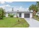 Charming single-story home with a well-maintained lawn, gray garage door, and inviting curb appeal at 25 Caddy Rd, Rotonda West, FL 33947