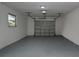 Spacious garage with gray epoxy flooring, window, and insulated garage door with natural light at 25 Caddy Rd, Rotonda West, FL 33947