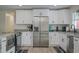 Modern kitchen with stainless steel appliances, sleek white cabinets, and granite countertops at 25 Caddy Rd, Rotonda West, FL 33947