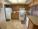 Kitchen with white appliances and wood cabinets at 3310 Loveland Blvd # 604, Port Charlotte, FL 33980
