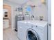 Practical laundry room with washer, dryer, and extra shelving at 3173 S Cranberry Blvd, North Port, FL 34286