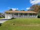 Ranch-style home with a large front porch and mature trees at 3173 S Cranberry Blvd, North Port, FL 34286