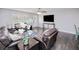 Open living space with dark hardwood floors and a large TV at 3173 S Cranberry Blvd, North Port, FL 34286