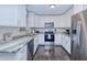 Modern kitchen with white cabinets, granite counters, and stainless steel appliances at 3173 S Cranberry Blvd, North Port, FL 34286