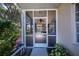 Cozy screened porch with tiled floor, ceiling fan, and access to the yard at 1307 Red Oak Ln, Port Charlotte, FL 33948