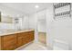 Bathroom with wood vanity, toilet and view into bedroom at 1 Colony Point Dr # 16B, Punta Gorda, FL 33950