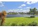 Serene lake view with lush landscaping and fountain at 7093 Mikasa Dr, Punta Gorda, FL 33950