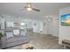 Open concept living room with gray sofa and wood-look floors at 25 Caddy Rd, Rotonda West, FL 33947
