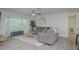 Living room features gray sofas, wood-look floors and a ceiling fan at 25 Caddy Rd, Rotonda West, FL 33947