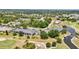 Elevated view of property in a golf community featuring lush landscaping, mature trees, and a serene water feature at 1355 Saxony Cir # 211, Punta Gorda, FL 33983