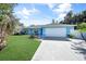 Light blue house with a white garage door and a spacious lawn at 4040 S Cranberry Blvd, North Port, FL 34286