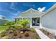 Single-story home with a gray exterior, palm trees, and a paved walkway at 9973 Calumet Blvd, Port Charlotte, FL 33981