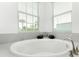 Relaxing bathroom with soaking tub, grey tile, and large windows at 9973 Calumet Blvd, Port Charlotte, FL 33981