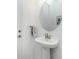 Convenient half-bath with pedestal sink and a large round mirror at 9973 Calumet Blvd, Port Charlotte, FL 33981