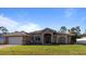 Single-story home with a beige exterior, double door entry, and a two-car garage at 4555 Fernway Dr, North Port, FL 34288