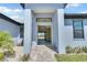 Inviting entryway to light blue home with a paved walkway leading to the front door at 13164 Amaryllis Cir, Port Charlotte, FL 33981