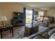 Spacious living room featuring a large TV, comfortable seating, and sliding glass doors leading to the backyard at 860 Columbia St, Port Charlotte, FL 33948