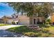 Two-story house with beige exterior, attached garage, and landscaping at 10044 Winding River Rd, Punta Gorda, FL 33950