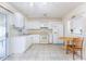 Functional kitchen featuring white cabinetry and appliances, tile flooring, and an adjacent dining area for easy meals at 2376 Starlite Ln, Port Charlotte, FL 33952