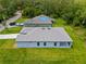 Aerial image showing a home featuring a gray roof, well-kept lawn, and a cozy covered patio at 2404 Hanford Ln, North Port, FL 34288