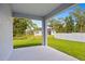 View from the back porch looking out at a green lawn and trees at 2404 Hanford Ln, North Port, FL 34288