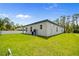 Green, expansive backyard shows the edge of the home at 2404 Hanford Ln, North Port, FL 34288