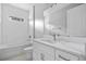 Bathroom vanity with sink, mirror, toilet, and subway tile tub at 2404 Hanford Ln, North Port, FL 34288