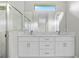 Modern bathroom with double sink vanity, marble countertop, large mirror and glass-enclosed shower at 2404 Hanford Ln, North Port, FL 34288