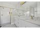 Modern bathroom featuring double sink vanity, marble countertop, and subway tile shower with gold-framed glass at 2404 Hanford Ln, North Port, FL 34288