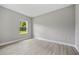 Neutral bedroom featuring a window, grey walls, and light-colored laminate flooring at 2404 Hanford Ln, North Port, FL 34288