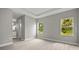 Bright bedroom featuring tray ceilings, wood-look floors, and large windows with a view to lush landscaping at 2404 Hanford Ln, North Port, FL 34288