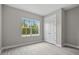 Bright bedroom with lush landscaped view, white closet and light wood-look floors at 2404 Hanford Ln, North Port, FL 34288