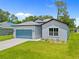 Charming single-story home with a well-manicured lawn and a blue garage door adding a pop of color at 2404 Hanford Ln, North Port, FL 34288