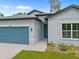 Close up of a home with a blue garage and entry door, complemented by a well-maintained lawn at 2404 Hanford Ln, North Port, FL 34288
